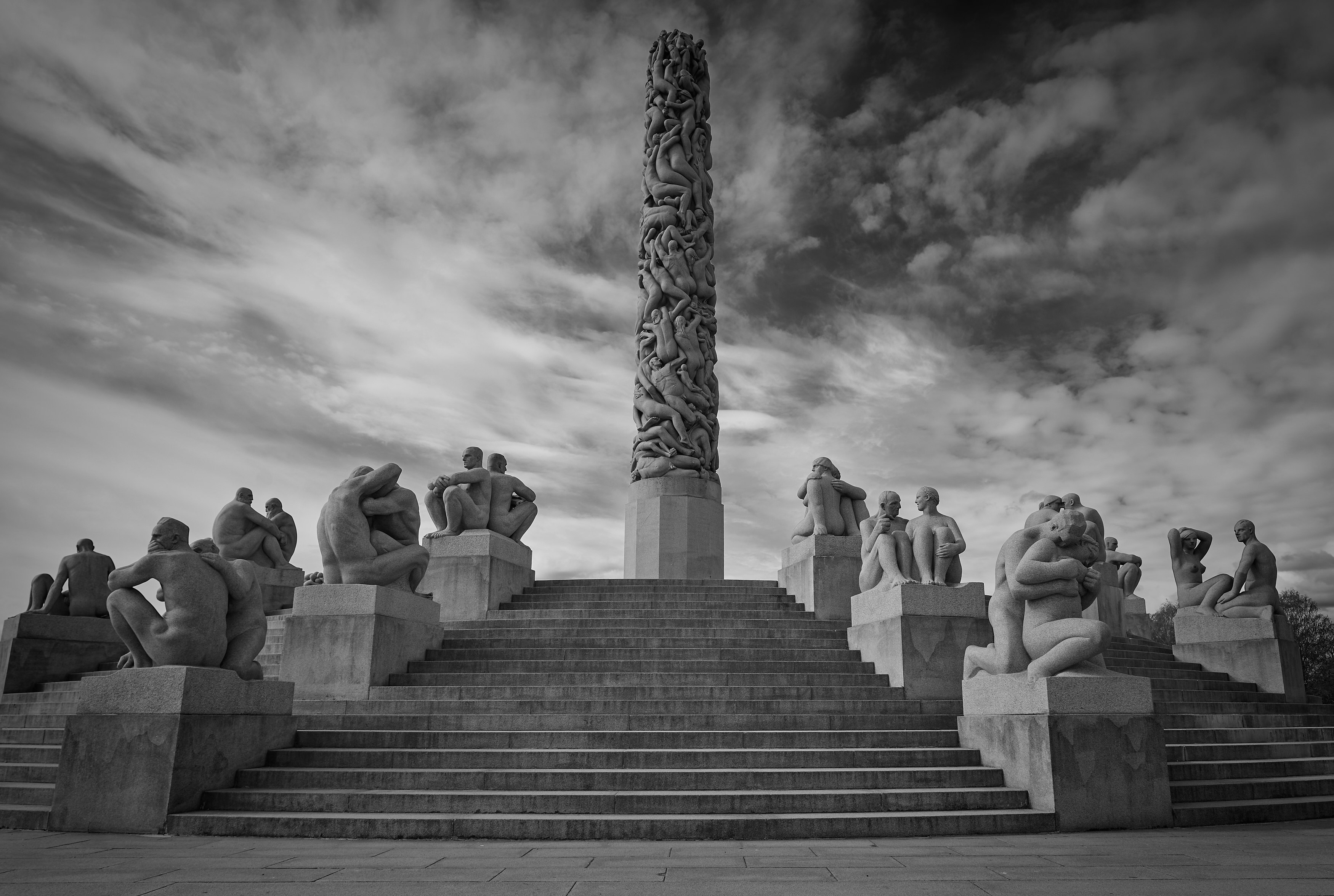 grayscale photo of people sitting on concrete stairs